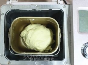 除黄油外，将面团中的所有原材料放入面包桶中，启动1个揉面程序，揉到面团光滑。