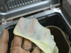 加入软化好的黄油，揉至扩展阶段，这时候面团可以撑出较薄的膜。