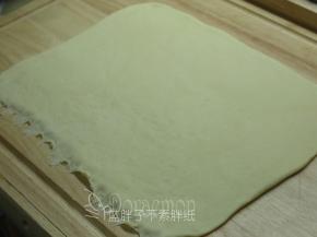 松弛好的面团排气，用擀面杖擀成长方形面团（30*25cm）。底端用手指压扁。