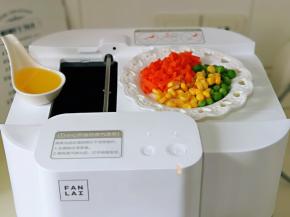 准备好橄榄油，玉米粒，胡萝卜丁，豌豆粒，启动机器，热锅后，将这两样倒入锅中，第一次投料。