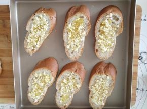 法棍切成1厘米厚的片，涂抹黄油蒜泥，放入金盘中。
