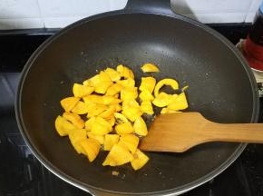 锅里热油放入南瓜块煸炒