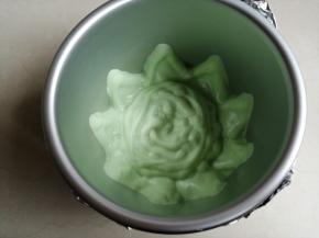 把绿色的蛋糕糊挤在模具底部，并贴着模具壁挤出一个个小山丘形状，要挤得厚一点