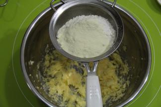 低粉和奶粉混合，过筛到打好的黄油糊中，用刮刀压拌均匀。