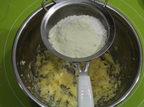 低粉和奶粉混合，过筛到打好的黄油糊中，用刮刀压拌均匀。