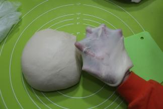 打好面团取出，两手握面团，向身体外侧折叠收圆，切一块下来，慢慢扯开就能看到薄薄的手套膜。