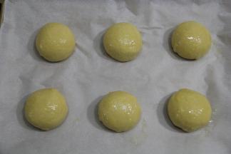 排入垫有油纸的烤盘中，一盘6个，可以两盘。只有一只烤箱的建议做一半六个。轻轻刷上一层全蛋液。稍微喷一点水。