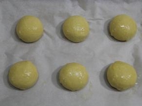 排入垫有油纸的烤盘中，一盘6个，可以两盘。只有一只烤箱的建议做一半六个。轻轻刷上一层全蛋液。稍微喷一点水。