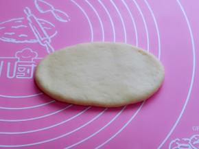 取一块面团，用擀面杖擀出椭圆形，如图。