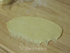 松弛好的面团压扁，用擀面杖擀成长方形面团。翻面，面团的下端记得用手指压扁拉长，这样待会好粘合。