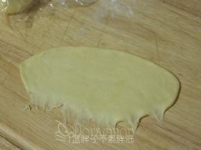 松弛好的面团压扁，用擀面杖擀成长方形面团。翻面，面团的下端记得用手指压扁拉长，这样待会好粘合。