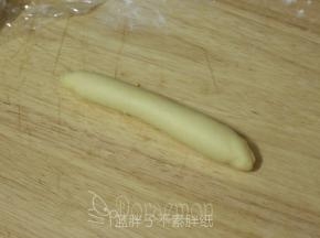 将面团由上往下卷起来。再松弛10分钟，松弛好的面团继续搓长一点。