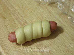 .将面团缠绕在香肠上，收口记得藏在里面。