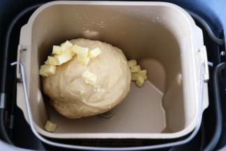 选择面包机和面程序开始揉面，揉面程序结束后放入黄油，继续选择揉面程序；