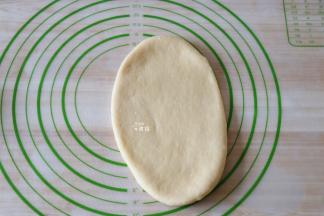 用擀面杖将面团揉成牛舌状；