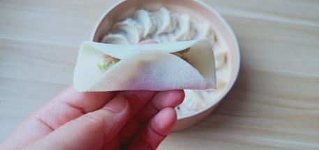 饺子皮半圈沾一点点水，有利于粘合。饺子馅放一点，先把饺子皮中间捏一下。