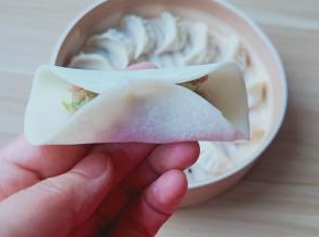 饺子皮半圈沾一点点水，有利于粘合。饺子馅放一点，先把饺子皮中间捏一下。