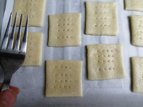 移到铺了油纸的烤盘上，用叉子在饼干胚上叉出多个小孔，这样可以防止饼干在烘烤的时候鼓胀变形