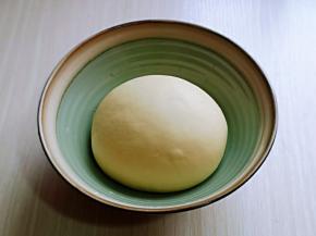 揉好的面团取出揉圆，放入器具中。