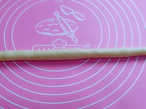 分割成等份的小面团，取一块面团，搓长条状。