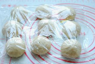 把面团取出来，排气、揉匀，平均分成9个小面团，分别滚圆，盖上保鲜膜，静置15分钟。