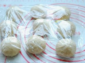 把面团取出来，排气、揉匀，平均分成9个小面团，分别滚圆，盖上保鲜膜，静置15分钟。