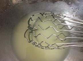 首先我们先制作蛋糕卷的部分。 水、色拉油倒入打蛋盆中，用蛋抽混合均匀，充分乳化。如图中状态。