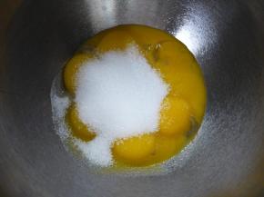 虎皮部分的制作。 蛋黄和糖放入打蛋盆中，隔温水加热，用打蛋器打发至糖全部融化后离水。