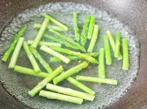  锅里水开放入几滴油和适量的盐， 将芦笋放入里面去焯水。