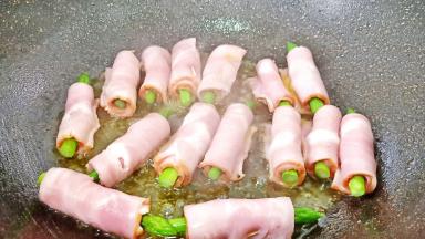 将培根芦笋卷放入油锅中小火慢慢煎。