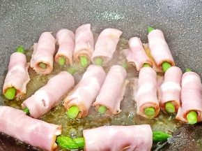 将培根芦笋卷放入油锅中小火慢慢煎。