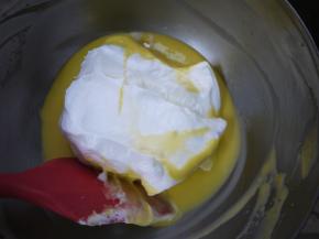 把3分之1的蛋白霜加入到蛋黄糊中，用刮刀混合均匀。