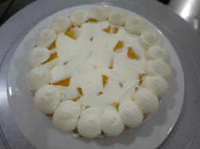 在蛋糕片上抹上奶油，放上芒果丁。边上用圆形裱花嘴挤上圆球奶油。