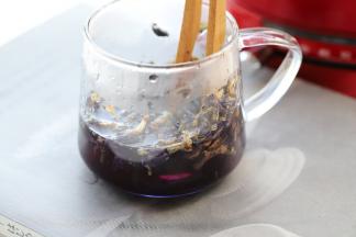 利用勺子压榨出蝶豆花汁。