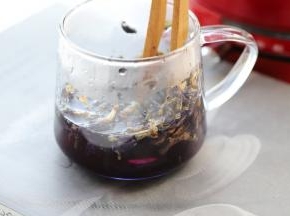 利用勺子压榨出蝶豆花汁。