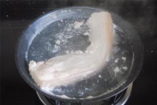 大概能用筷子扎穿就捞出来，这时候的五花肉还未熟，里面切开的时候还是有粉红的，用温水清洗干净表面的浮沫。