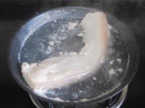 大概能用筷子扎穿就捞出来，这时候的五花肉还未熟，里面切开的时候还是有粉红的，用温水清洗干净表面的浮沫。