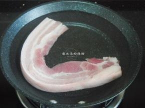 五花肉挑选瘦肉比较多的那段，肥肉不多吃起来口感不至于很油腻，洗干净，用刀刮去皮上的细毛，冷水下锅，煮沸后转小火。