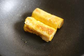 将卷好的香蕉卷放入锅中，小火煎至两面金黄。