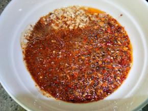 这功夫油温也降下来了，把油均匀淋在刚才的辣椒芝麻那个碗里