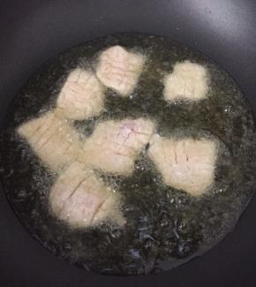 油烧至八成热时放入肉片，炸至金黄色。