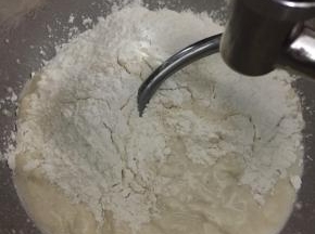 加入高筋面粉和酵母，先慢速搅拌到材料均匀后转中速搅拌。