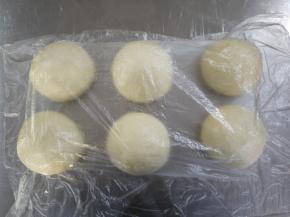 发酵好后将面团分割成6等分，约150g每个，滚圆后盖保鲜膜松弛15分钟。
