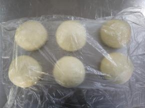 发酵好后将面团分割成6等分，约150g每个，滚圆后盖保鲜膜松弛15分钟。