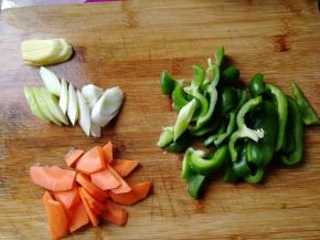期间胡萝卜洗净去皮切片，姜切片，青椒去籽清洗干净，切块。大葱洗净，斜刀切片。