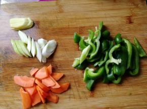 期间胡萝卜洗净去皮切片，姜切片，青椒去籽清洗干净，切块。大葱洗净，斜刀切片。