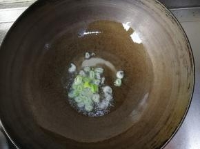 干净无水锅里，开大火，倒入玉米油，同时切一点大葱丝放入爆香。