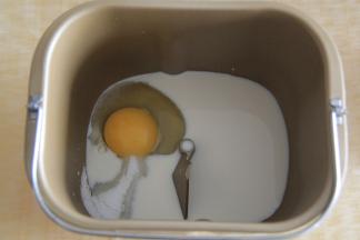 面包桶中，如图装好搅拌叶片，先放牛奶，鸡蛋。糖、盐放在面包桶的两个角落，不要直接接触。