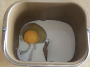 面包桶中，如图装好搅拌叶片，先放牛奶，鸡蛋。糖、盐放在面包桶的两个角落，不要直接接触。