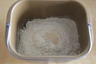 放入多谷物面包粉，粉上挖洞，放入酵母。